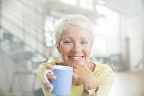 Ältere Frau trinkt eine Tasse Kaffee, lizenzfreies Stockfoto