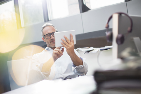 Businessman using digital tablet at office desk stock photo