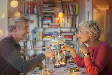 Älteres Paar stößt bei einem romantischen Abendessen aufeinander an - CAIF14855