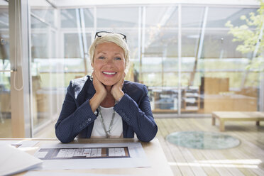 Businesswoman smiling in office - CAIF14916