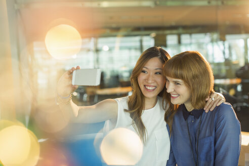 Geschäftsfrauen nehmen Handy-Selfie im Büro - CAIF14940