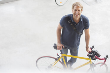 Lächelnder Mann stehend mit Fahrrad - CAIF14948