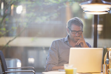 Businessman working on laptop in office - CAIF14951