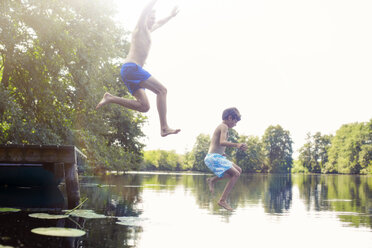 Vater und Sohn springen in den See - CAIF14985