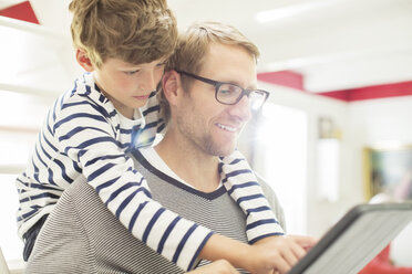 Vater und Sohn benutzen ein digitales Tablet - CAIF14989