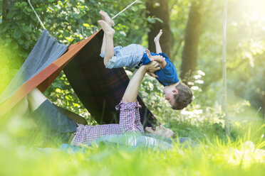 Father and son playing near camping tent - CAIF14993