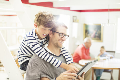 Vater und Sohn benutzen ein digitales Tablet - CAIF14994