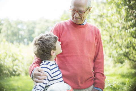 Großvater und Enkel umarmen sich im Freien, lizenzfreies Stockfoto