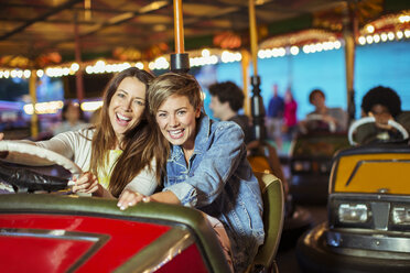 Zwei fröhliche Frauen auf dem Autoscooter im Vergnügungspark - CAIF15035