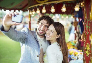 Lächelndes Paar macht Selfie im Vergnügungspark - CAIF15037