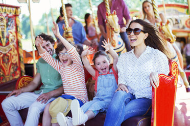 Family on carousel in amusement park - CAIF15041