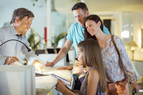 Familie mit zwei Kindern an der Rezeption in der Hotellobby - CAIF15054