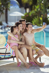 Familie mit zwei Kindern macht ein Selfie am Schwimmbad - CAIF15068