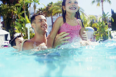 Father with daughter and son playing in swimming pool - CAIF15073