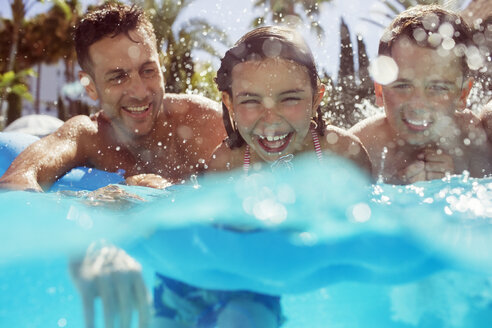 Vater schwimmt mit seinen beiden Kindern im Schwimmbad - CAIF15077