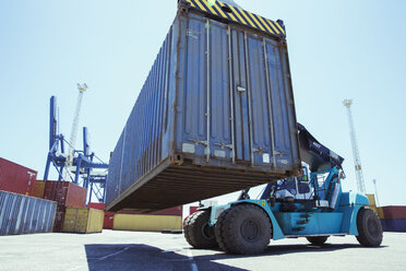 Low angle view of crane lifting cargo container - CAIF15084