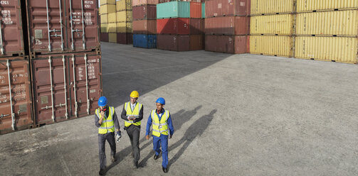 Geschäftsleute und Arbeiter gehen in der Nähe von Frachtcontainern - CAIF15110