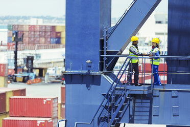 Worker and businessman shaking hands on cargo crane - CAIF15128