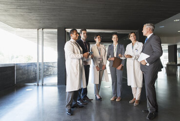 Scientists and business people talking in lobby - CAIF15157