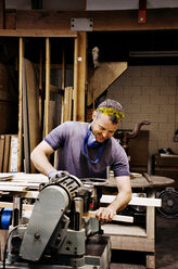 Carpenter using machinery in workshop - CAVF06063