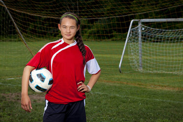 Porträt einer selbstbewussten Fußballspielerin auf dem Spielfeld - CAVF06102