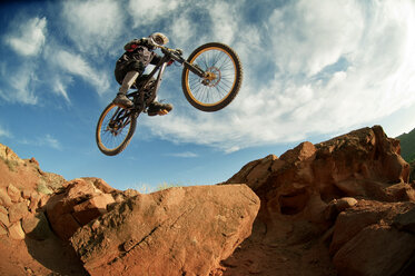 Low angle view of mountain biker performing stunt while cycling - CAVF06199