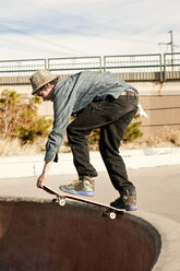 Mann fährt Skateboard auf einer Skateboard-Rampe - CAVF06238