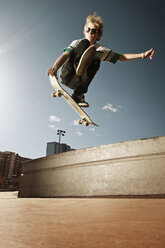 Low angle view of man performing stunt against sky on sunny day - CAVF06245