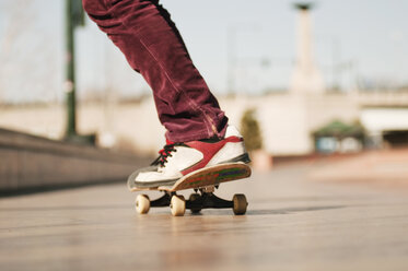 Low section of man skateboarding on footpath - CAVF06254