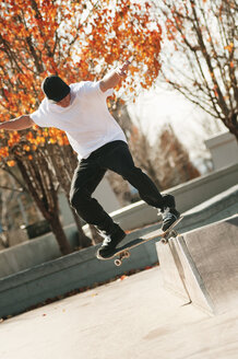Mann vollführt Stunt mit Skateboard an einem sonnigen Tag - CAVF06259