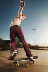 Shirtless Mann Skateboarden auf Sport-Rampe gegen Himmel - CAVF06265