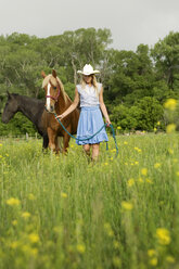 Frau mit Pferden auf grasbewachsenem Feld - CAVF06275