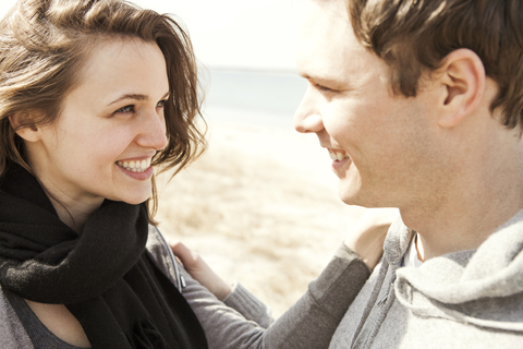 Glückliches Paar am Strand stehend, lizenzfreies Stockfoto