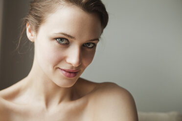 Portrait of woman standing against wall at home - CAVF06319