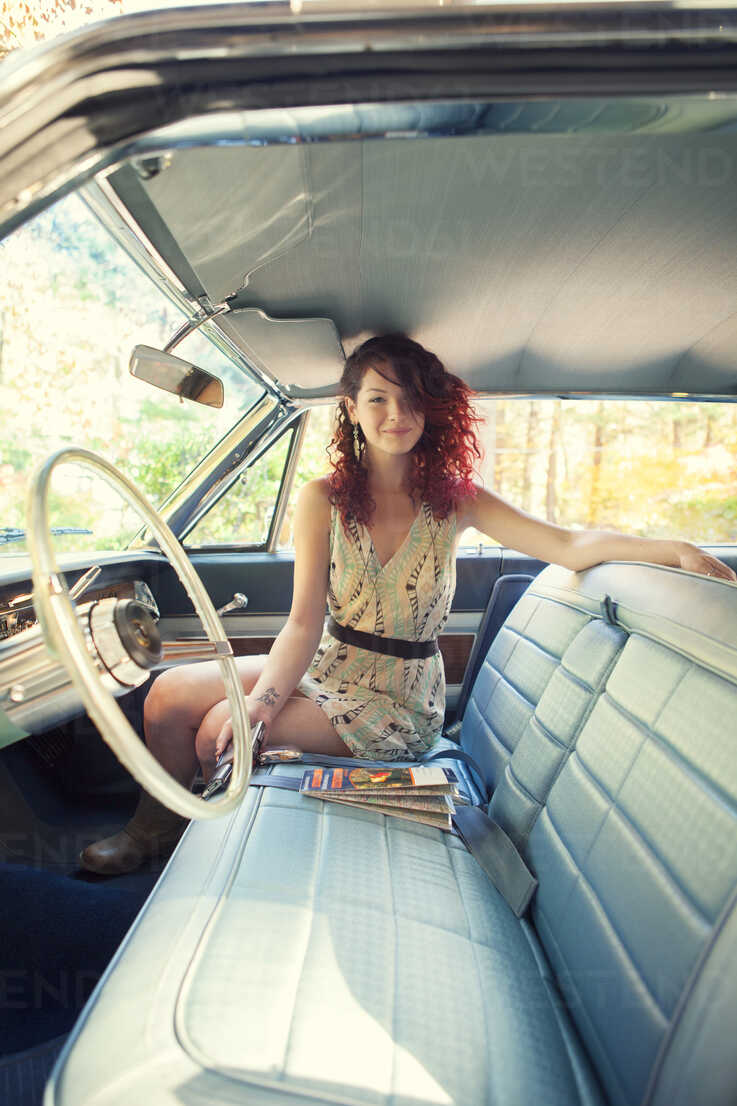 Portrait of woman sitting in vintage car stock photo