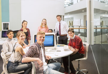 Gruppenbild von Jugendlichen mit ihrer Lehrerin am Tisch - CAIF15207