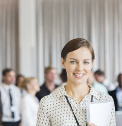 Porträt einer Geschäftsfrau im Büro mit einem Dokument in der Hand - CAIF15243