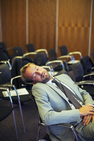 Geschäftsmann schläft im Konferenzraum, lizenzfreies Stockfoto