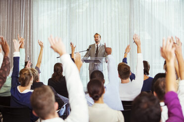 Geschäftsmann hält Präsentation im Konferenzraum, Menschen heben die Hände - CAIF15265