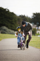 Mann bringt seinem Sohn das Fahrradfahren bei - CAVF06549