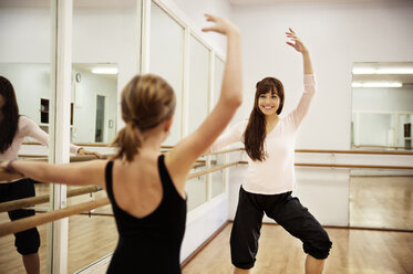 Mädchen tanzt mit Lehrer in Tanzstudio - CAVF06587