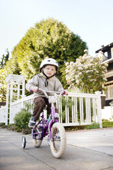 Porträt eines Jungen, der auf einem Fußweg Fahrrad fährt - CAVF06606