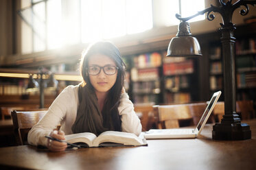 Porträt einer in einer Bibliothek sitzenden Frau - CAVF06722