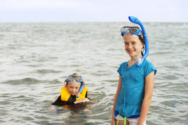 Porträt einer glücklichen Schwester und eines glücklichen Bruders beim Schwimmen im Meer - CAVF06753