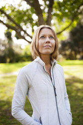 Thoughtful woman looking up while standing in field - CAVF06826