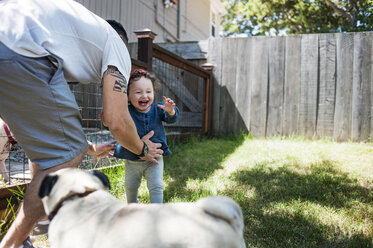 Happy family with dog playing in backyard - CAVF06955