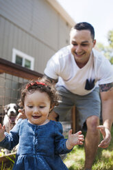Happy father playing with daughter in backyard - CAVF06957