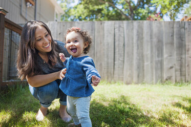 Happy mother looking at cute daughter in backyard - CAVF06958