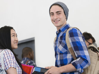 Porträt eines Universitätsstudenten mit Buch im Klassenzimmer - CAIF15350