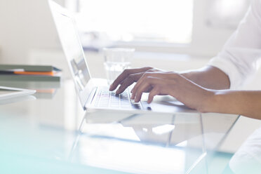 Hände einer Geschäftsfrau beim Tippen auf einem Laptop im Büro - CAIF15357